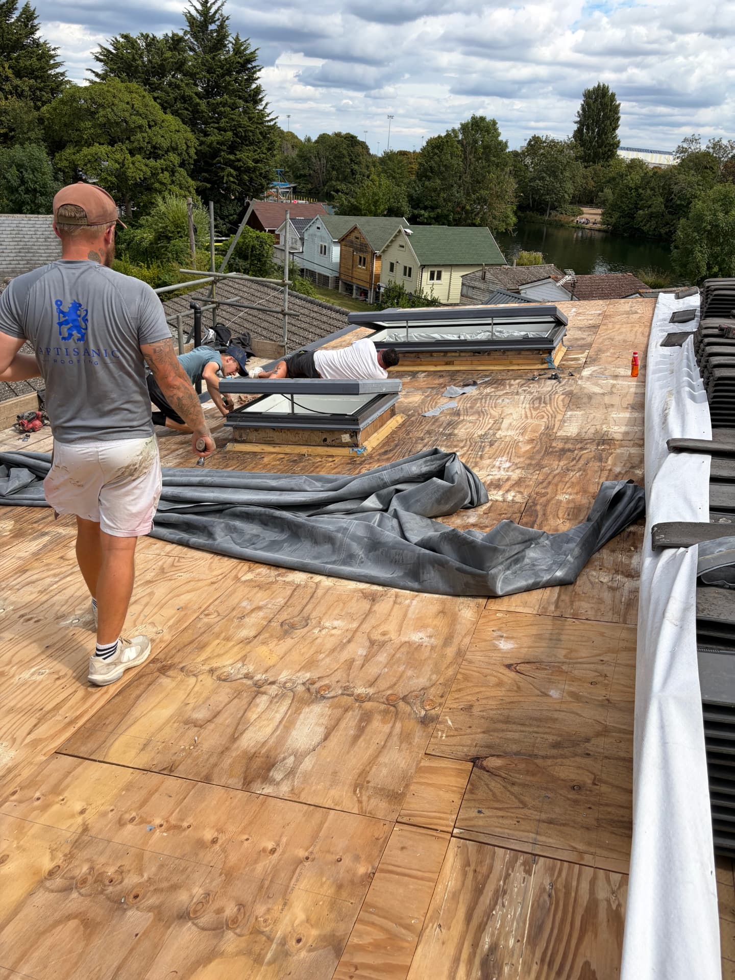 Artisanic Roofing team fitting rooflights on the exposed OSB deck before the EPDM goes down
