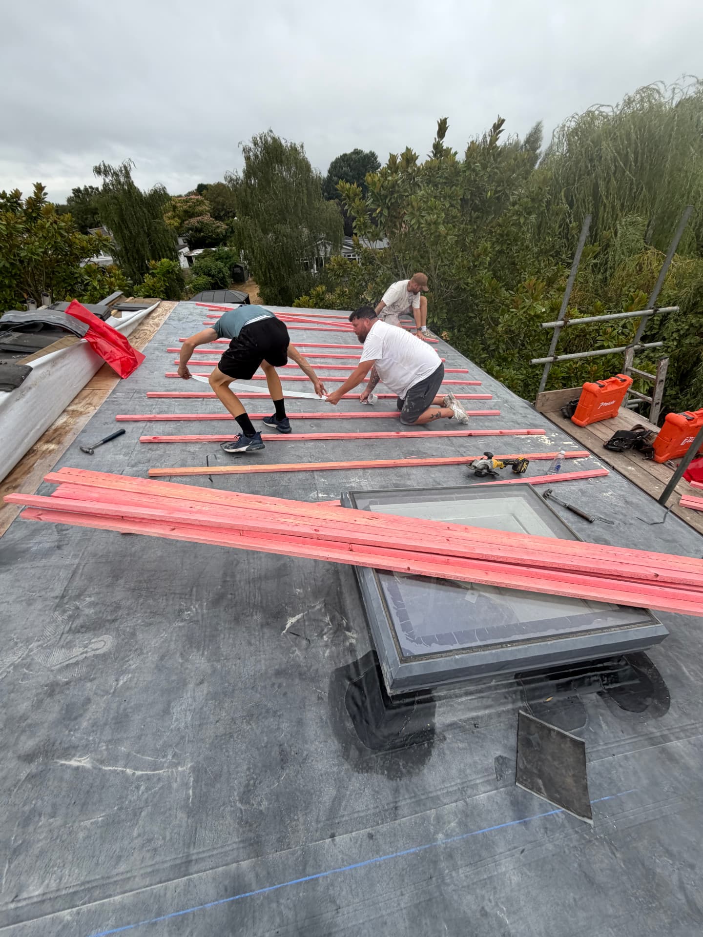 Roofers fitting treated counter battens over the EPDM membrane